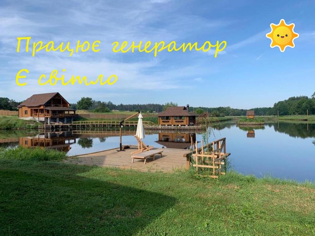a view of a lake with a house and a dock at GuestHouse on the Lake with Bathhouse 70 km from Kiev in Makariv
