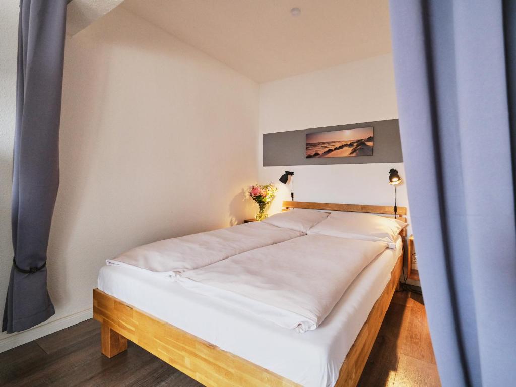 1 dormitorio con 1 cama blanca grande en una habitación en Smile, wunderschöne Wohnung direkt am Strand, en Harrislee