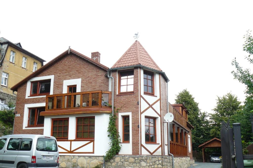 a tall brick house with a balcony on top of it at Chata na skale in Karpacz