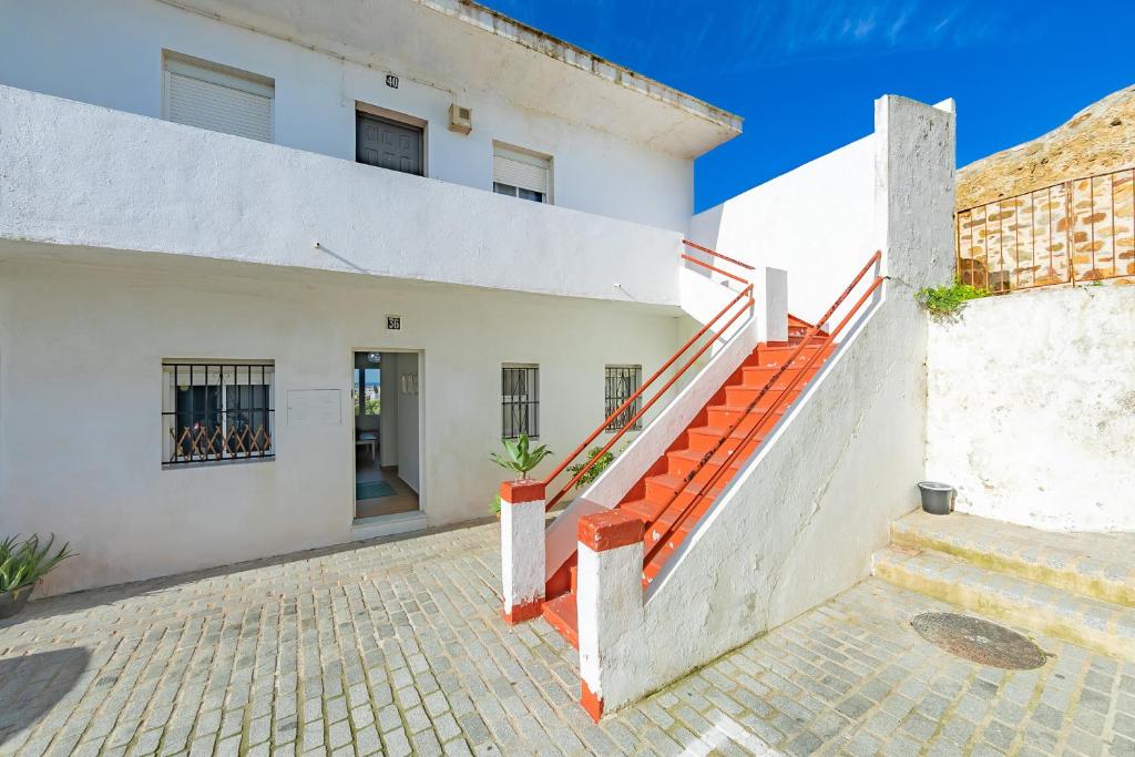 タリファにあるApto tranquilo en casco antiguoのオレンジ色の階段を用いた白い建物の外観