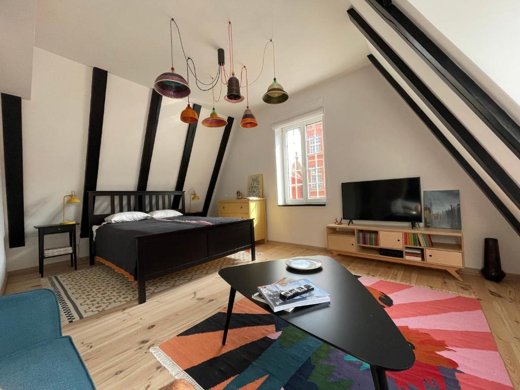 a living room with a bed and a table at Długa Design Apartment - Old Town in Gdańsk
