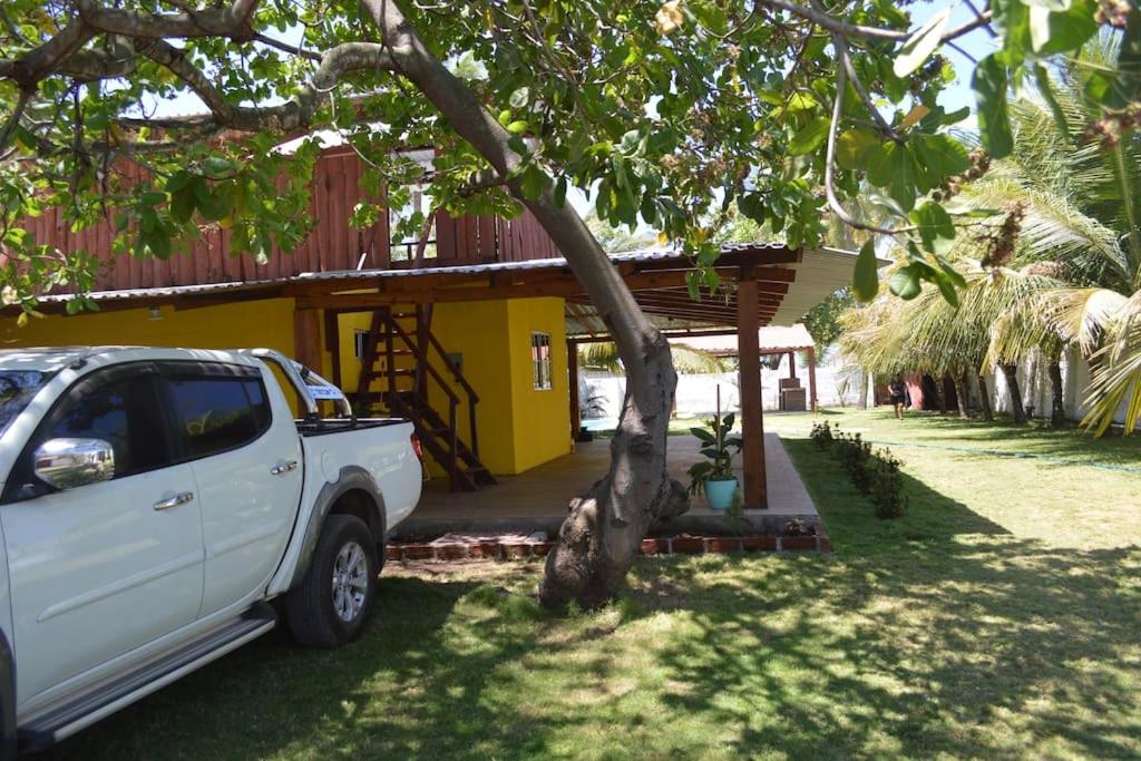 a white truck parked in front of a yellow house at RANCHO BOLMAR. Playa Metalio. Sonsonate. in Acajutla