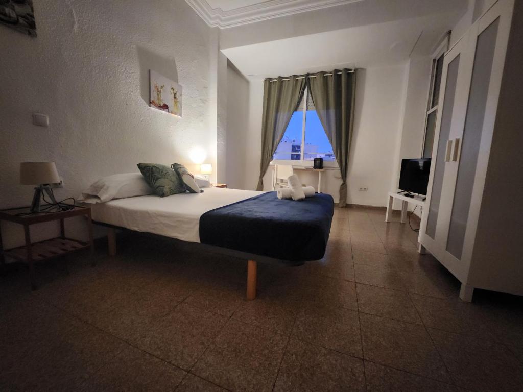 1 dormitorio con cama y ventana grande en eXperience Rooms Valencia, en Valencia