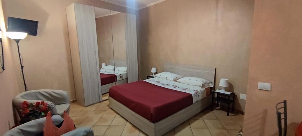 a small bedroom with a bed and a mirror at Casa Rosy.S in Pozzuoli