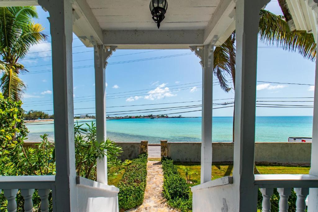 a porch with a view of the ocean at Folly & Guest House home in Governorʼs Harbour