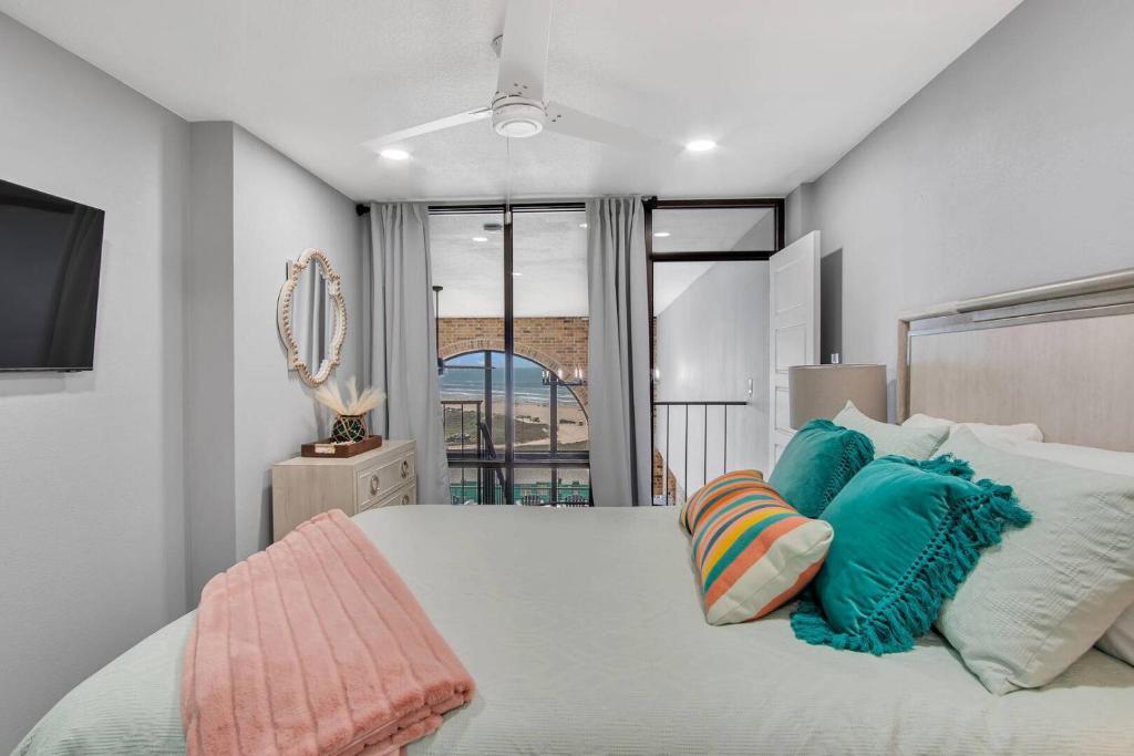 Una cama o camas en una habitación de Split Level Pentouse with Floor to Ceiling Arched Window and Panoramic View of the Coast