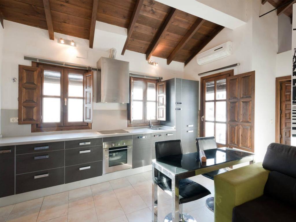 a kitchen with a table and a couch in a room at Loft wifi Centro espectacular terraza con todos los servicios in Granada