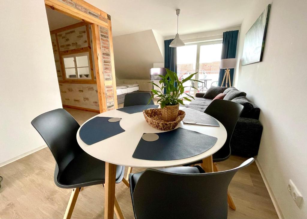 a dining table and chairs in a living room at Modernes Appartment mit Sauna nahe Burg im Spreewald in Vetschau