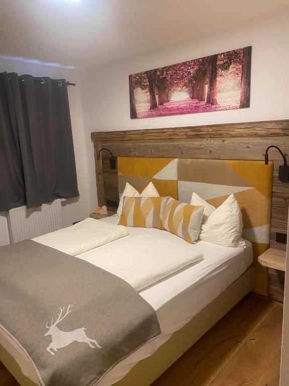 a bedroom with a bed with a wooden headboard at Haus Almweg in Kirchberg in Tirol
