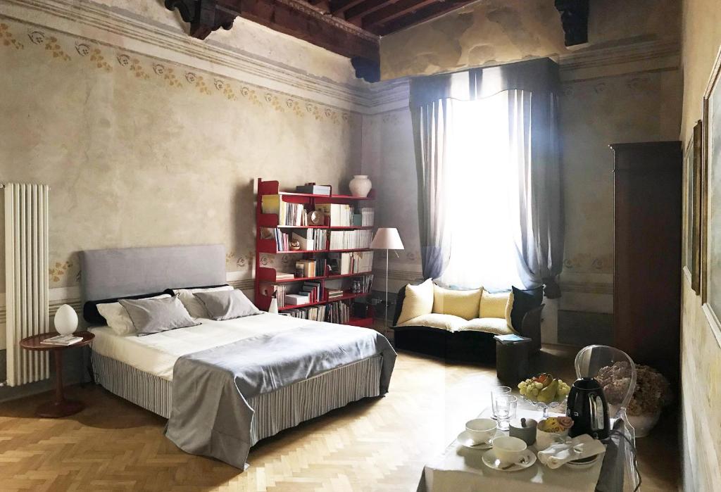 a bedroom with a bed and a couch and a table at Domus '400 in Pisa