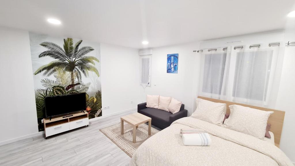 a living room with a bed and a tv at Appartement très lumineux in Sevran