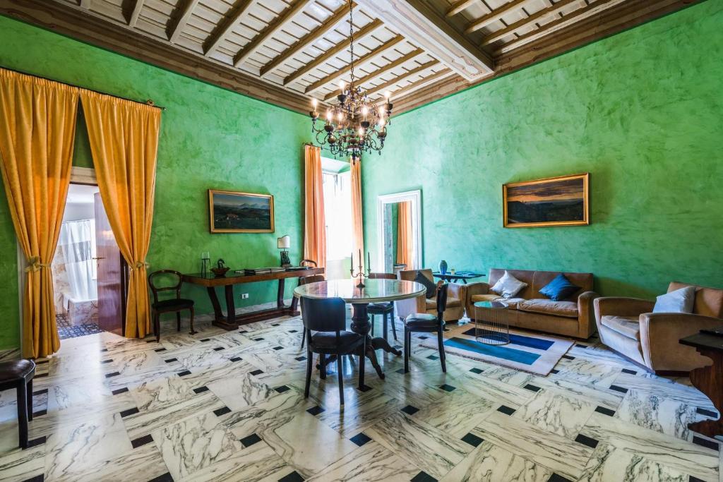 sala de estar con paredes verdes, mesa y sillas en ART DÉCO 1920 Vicino AUTOSTRADA 40 MIN ROMA, en Orte