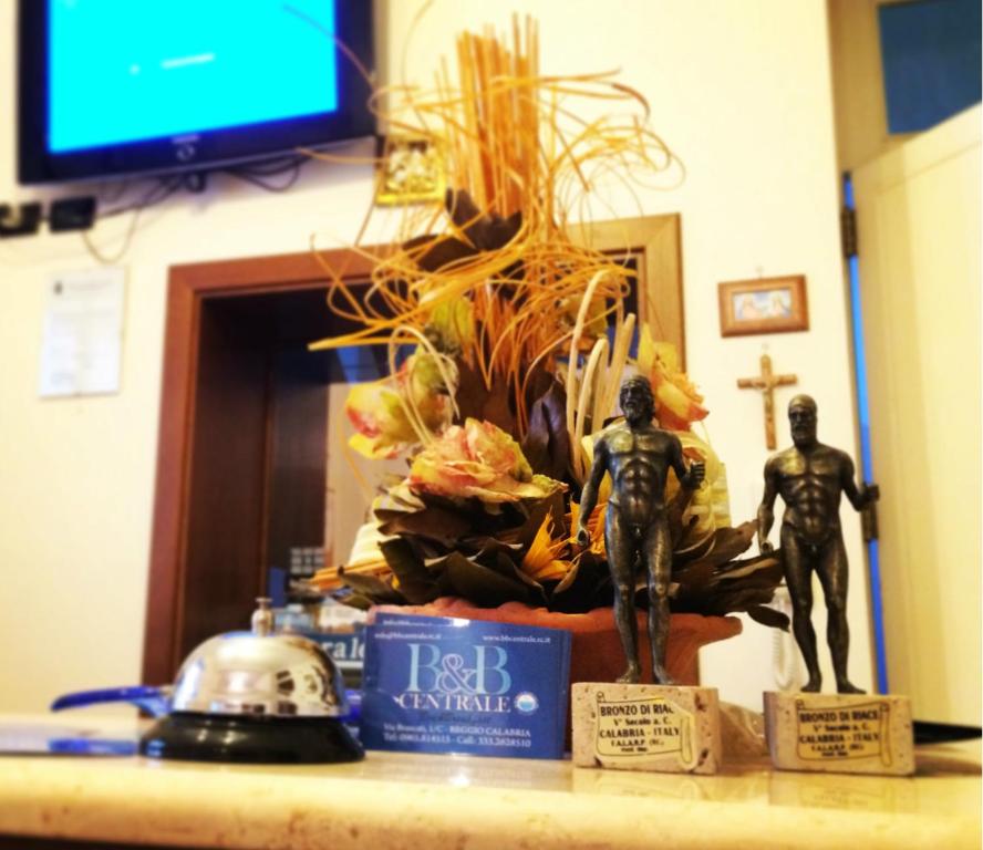 a counter with two statues on a table with a tv at B&B Centrale Affittacamere in Reggio di Calabria