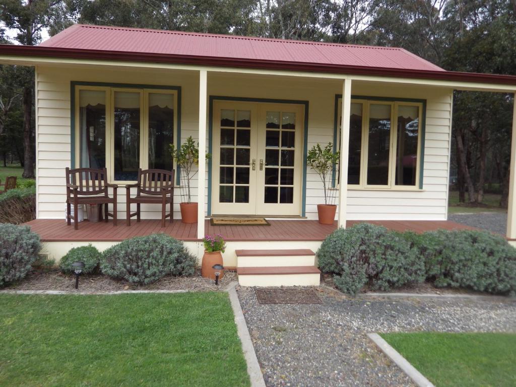 uma pequena casa com uma mesa e cadeiras num alpendre em The Retreat at Amryhouse em Ashbourne