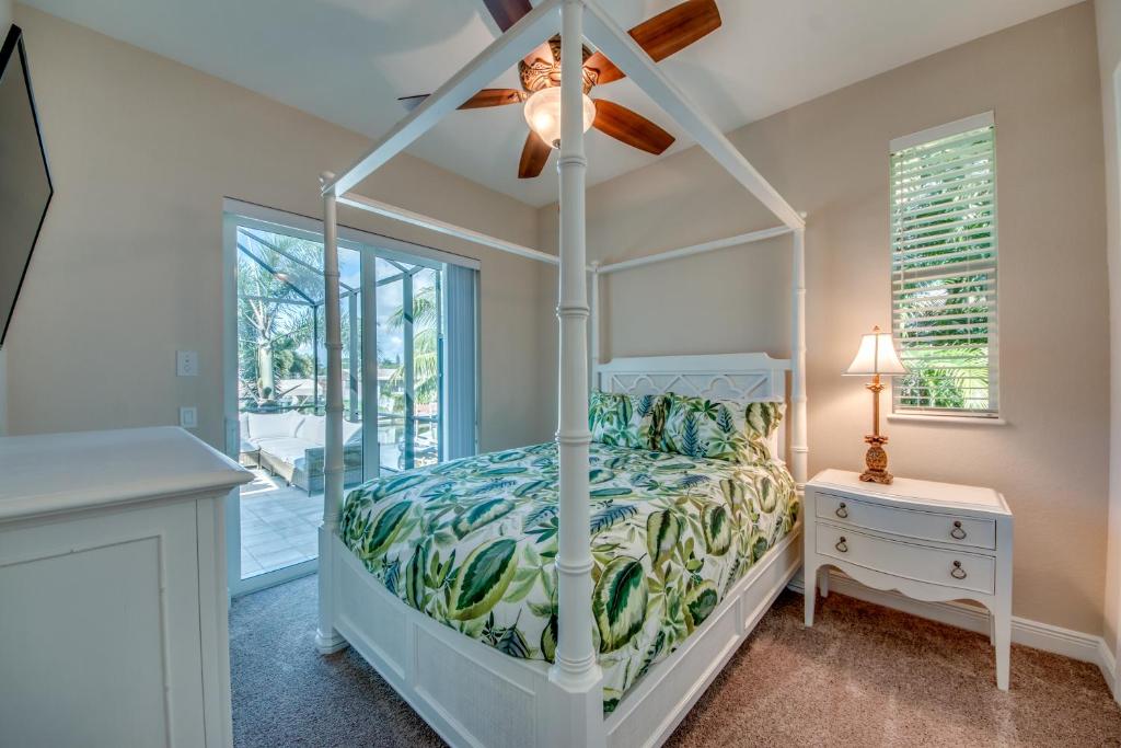 una camera da letto con un letto e un ventilatore a soffitto di Villa Blue Pavilion - Heated Pool - Sleeps 16 - Roelens Vacations a Cape Coral