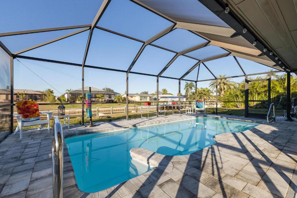 uma piscina debaixo de uma tenda com uma piscina em Villa Doc Life - Roelens Vacations - Beautiful 3 bedroom, 2 bath Pool home on a gulf access canal em Cape Coral
