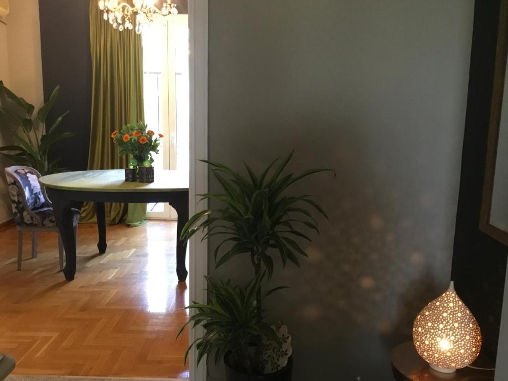 ein Esszimmer mit einem Tisch und einer Topfpflanze in der Unterkunft Athens Plaka Paul’s House in Athen