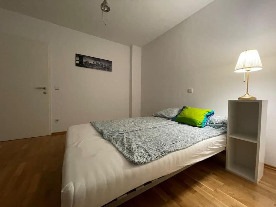 ein Schlafzimmer mit einem Bett mit einem grünen Kissen darauf in der Unterkunft modern and comfortable apartment next to vienna mainstation in Wien