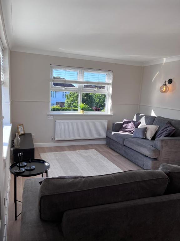 a living room with a couch and a window at Two-bedroom Apartment in Yeovil