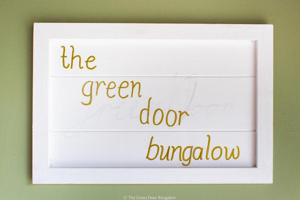 ein weißer Rahmen mit den Worten, die grüne Türverkleidung. in der Unterkunft The Green Door Bungalow in Naples