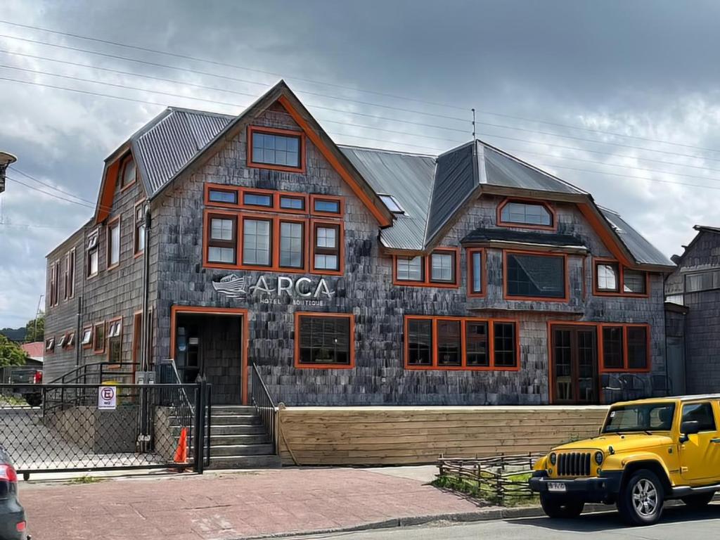 un camion giallo parcheggiato di fronte a un edificio di Hotel Boutique Arca Restaurant Achao Quinchao Chiloe ad Achao