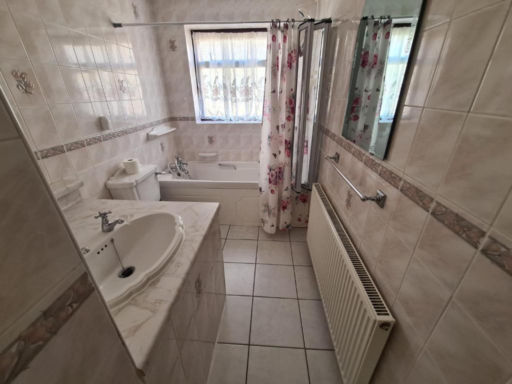 y baño con lavabo, bañera y aseo. en Mesa property services, en Grays