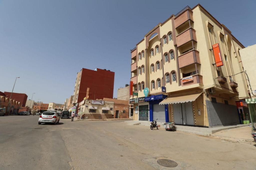 eine leere Straße in einer Stadt mit einem Gebäude in der Unterkunft حي الشهداء in El Aaiún