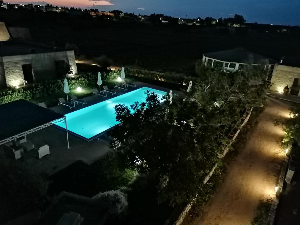 un'immagine di una piscina di notte di Tenuta Pigliano Hotel a Bagnolo del Salento