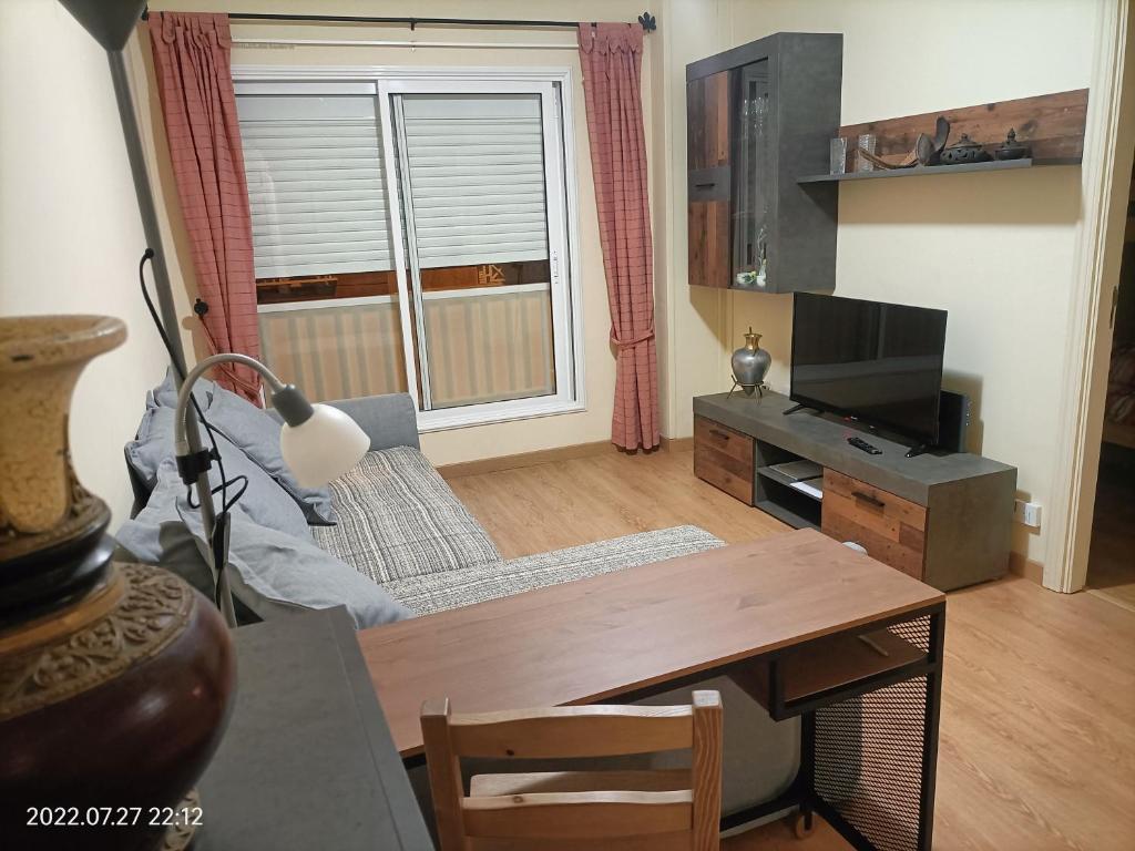 un salon avec une table et une télévision dans l'établissement Sunny Harbour, à Arona