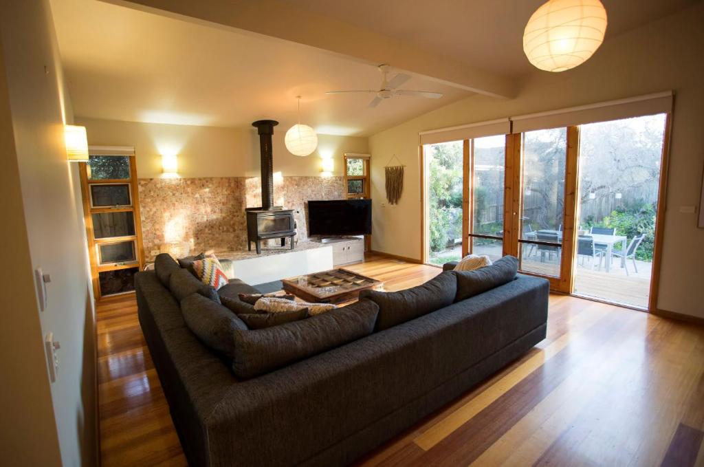 a living room with a large couch and a kitchen at SUNNY DAZE in Point Lonsdale