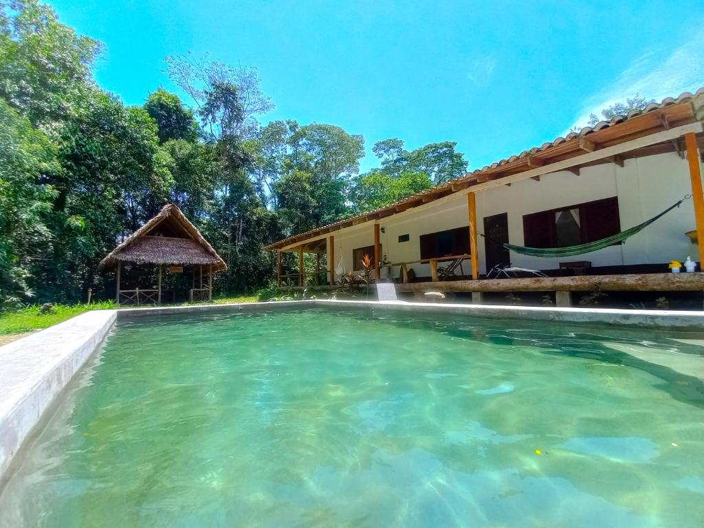 uma imagem de uma piscina em frente a uma casa em Wandari Lodge em Quince Mil