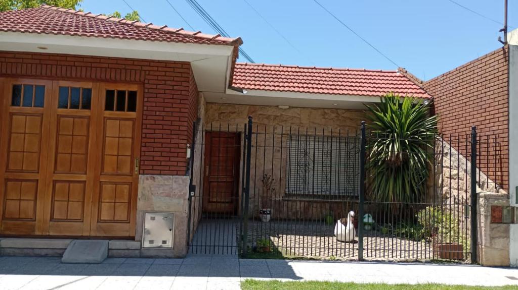 une maison avec une porte en bois et une clôture dans l'établissement “Chalet Carrasco” totalmente equipado, à Mar del Plata
