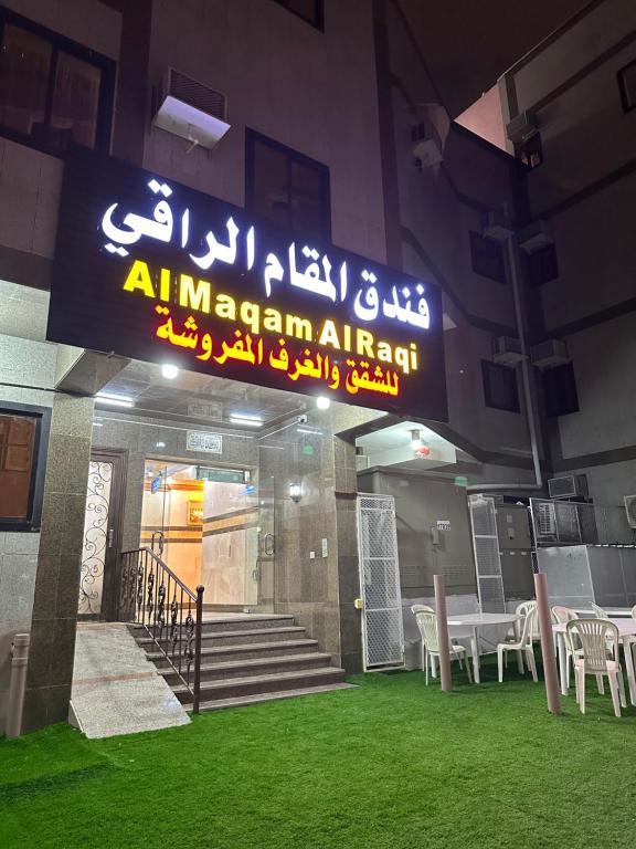a building with a sign for an american restaurant at فندق المقام الراقي للشقق والغرف المفروشة in Makkah
