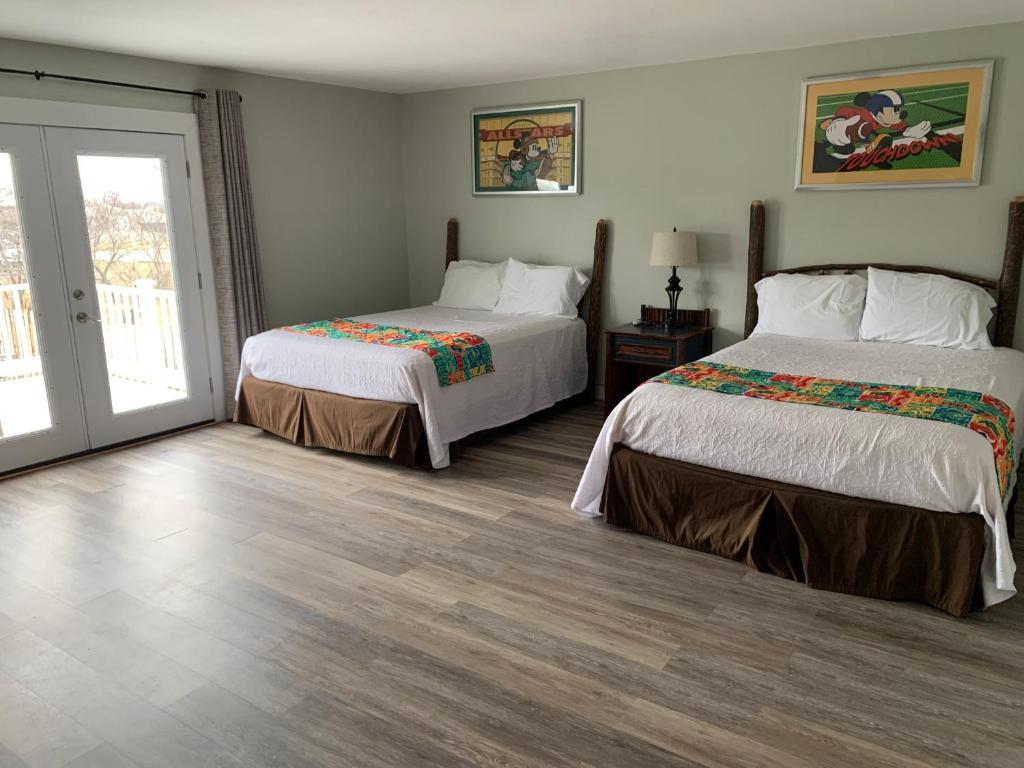 Marceline的住宿－Hotel Marceline，一间卧室设有两张床和滑动玻璃门