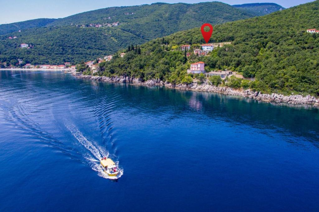 łódź w wodzie z czerwonym balonem w obiekcie Apartment Moscenicka Draga 7766b w mieście Mošćenička Draga