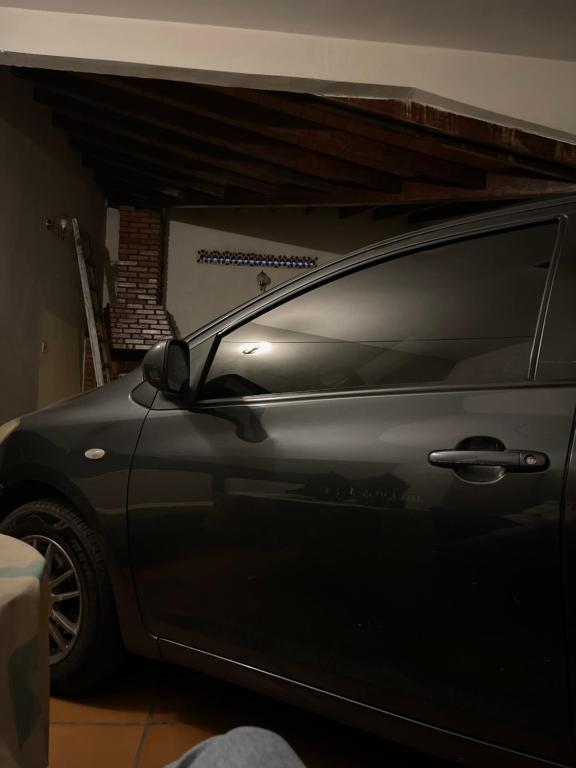 un coche aparcado en un garaje con la puerta abierta en Maje house, en Asunción