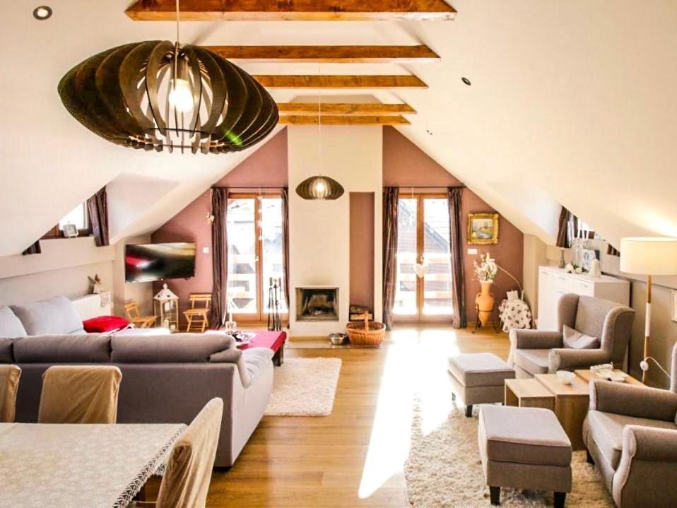 a living room with couches and chairs and a ceiling at Ararat Penthouse in Zlatibor