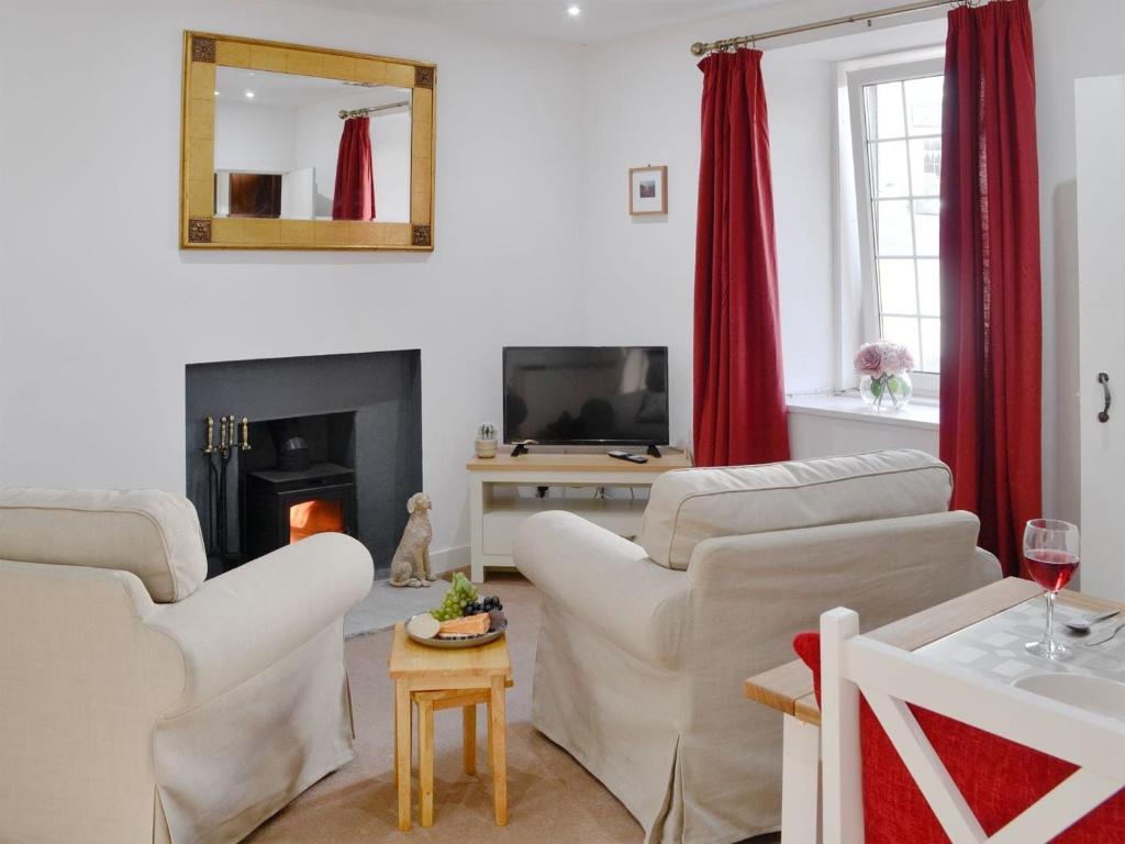a living room with white furniture and red curtains at Wylies Brae in New Galloway