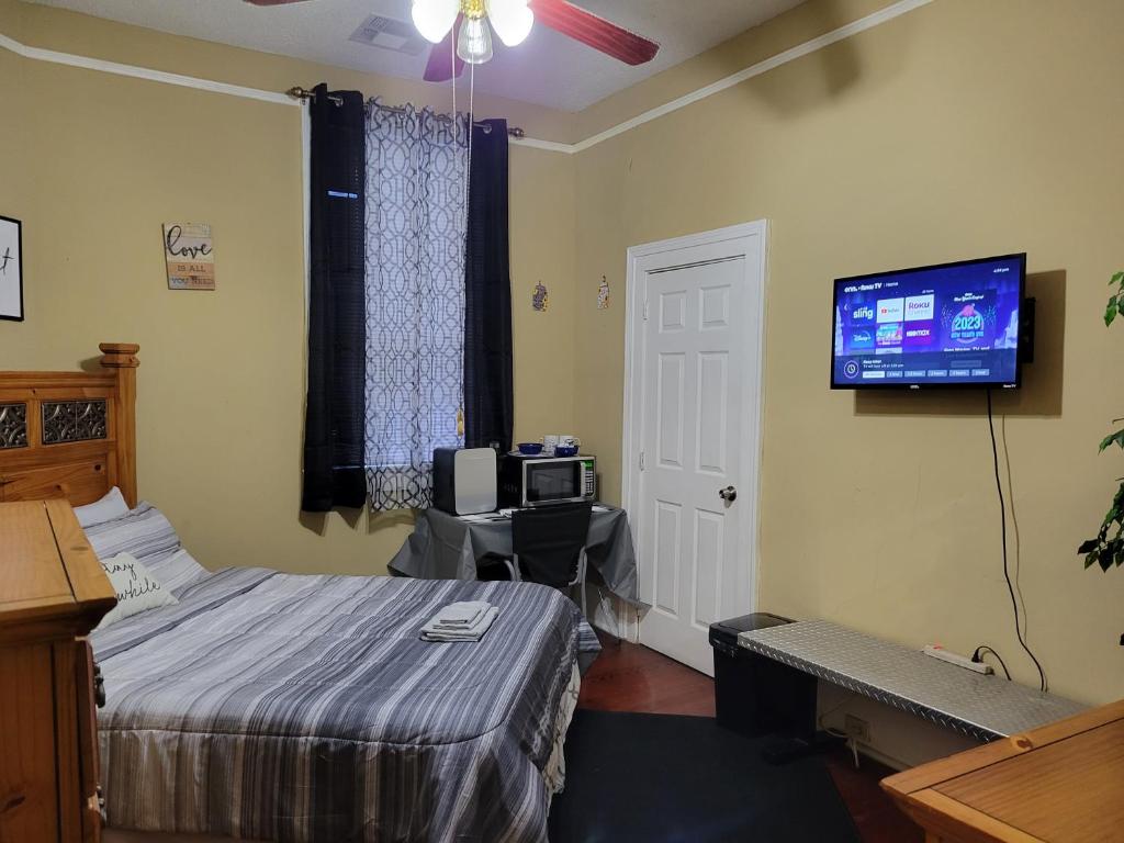 a bedroom with a bed and a flat screen tv at Mid City Fun in New Orleans