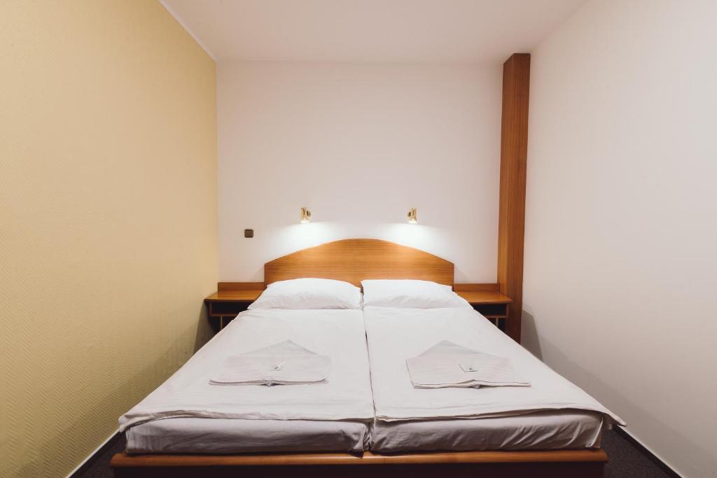 um quarto com uma cama com lençóis brancos em Hotel Annahof em Domašov