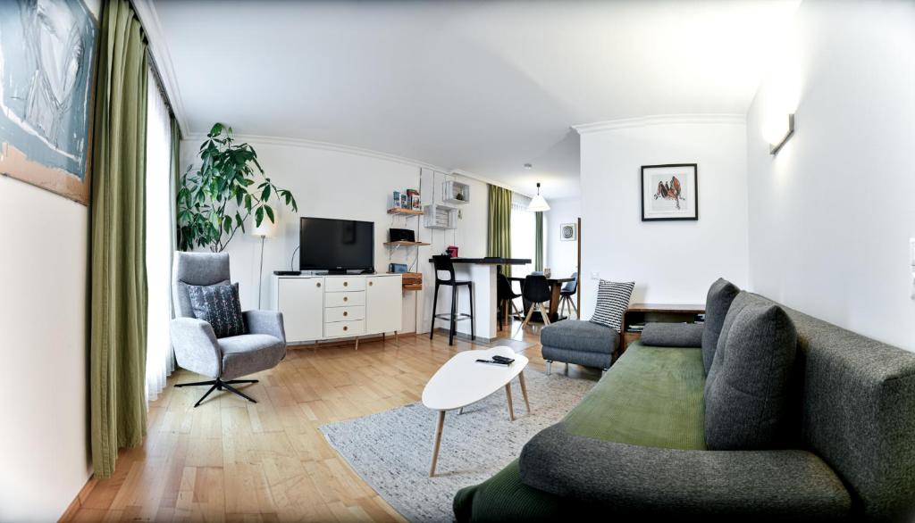 a living room with a couch and chairs and a table at Ferienwohnung in der Sonnenstadt Lienz in Lienz