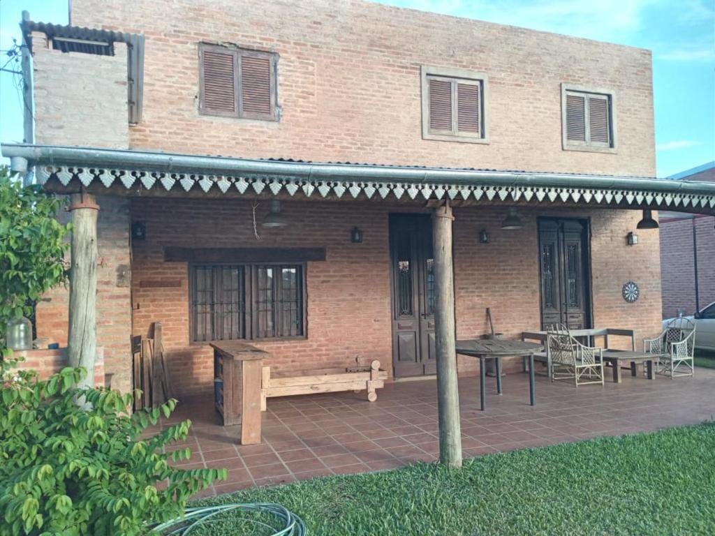 een gebouw met een patio met een bank en een tafel bij Hermosa Casa en Paso de la Patria in Paso de la Patria