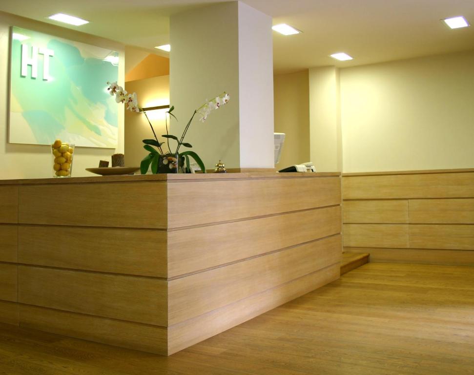 a reception desk in a hospital room with flowers at Hotel Touring in Pisa