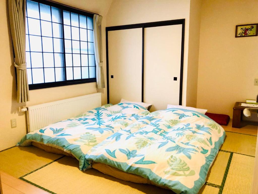 a bed in a room with a large window at Otaru Garden Stay in Otaru