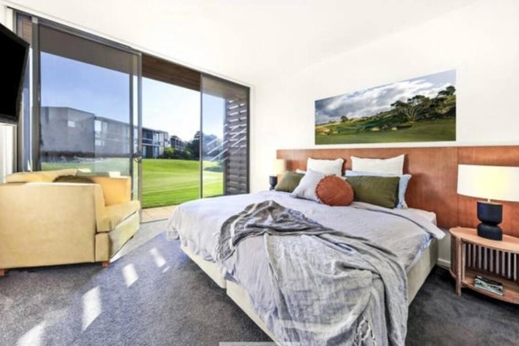 a bedroom with a bed and a large window at Moonah Links Apartment 45 Lovely 1 bedroom holiday home with heated pool in Fingal