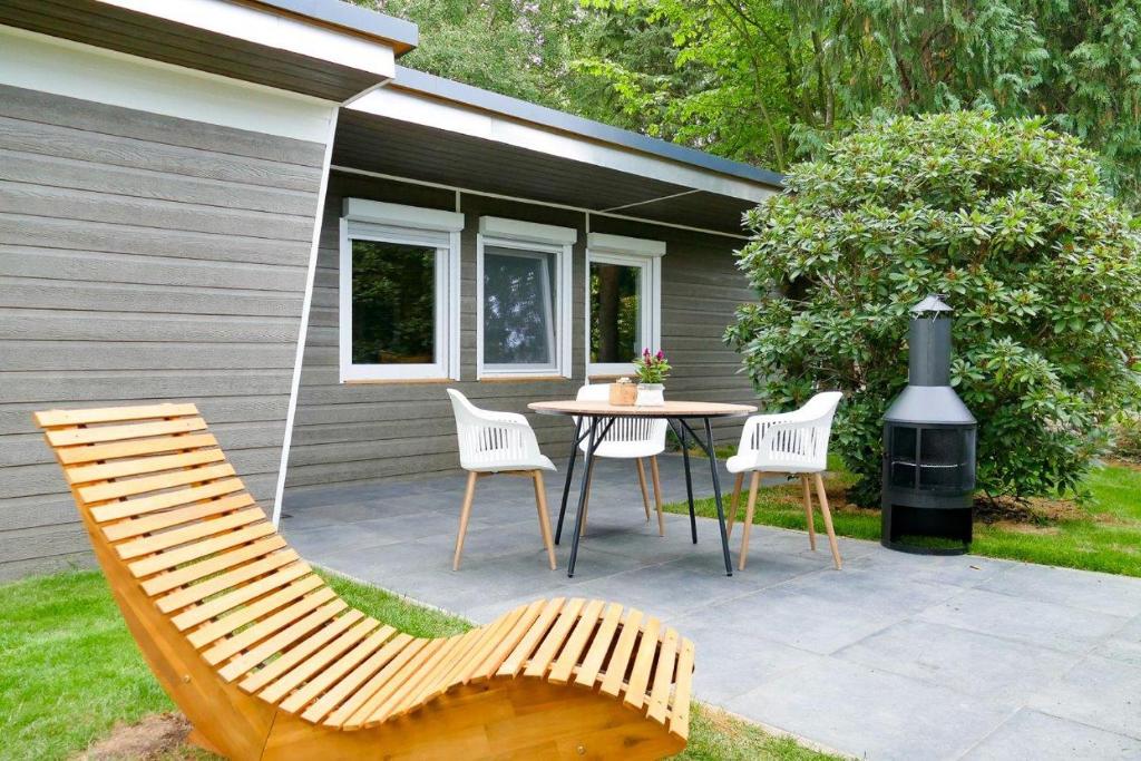 a patio with a table and chairs and a stove at Ferienhaus Lucie Kiebitzsee in Falkenberg
