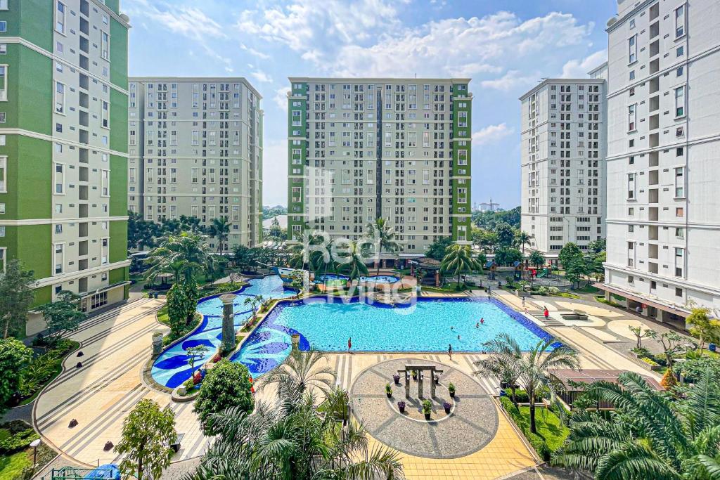 an overhead view of a large swimming pool with tall buildings at RedLiving Apartemen Kalibata City - Homy Jasen Tower Jasmine in Jakarta