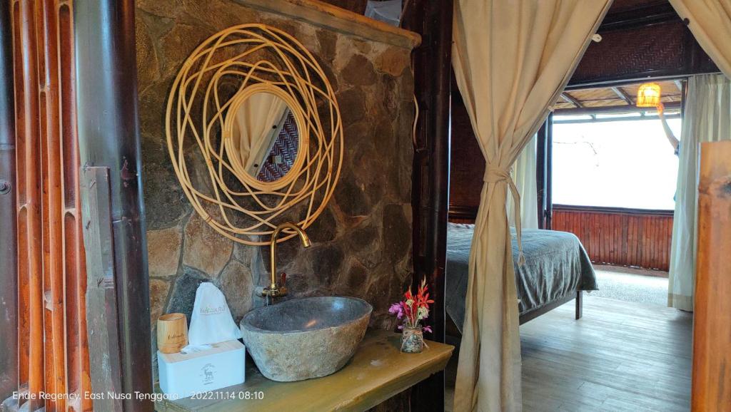 um quarto com uma parede de pedra com uma tigela sobre uma mesa em Kelimutu Paradiso Resort em Kelimutu