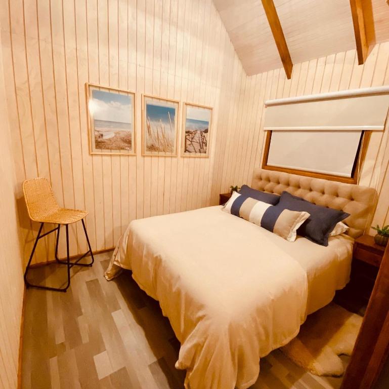 um quarto com uma cama e uma cadeira em Colico Tiny Lodge - jacuzzi-Terraza em Catrico