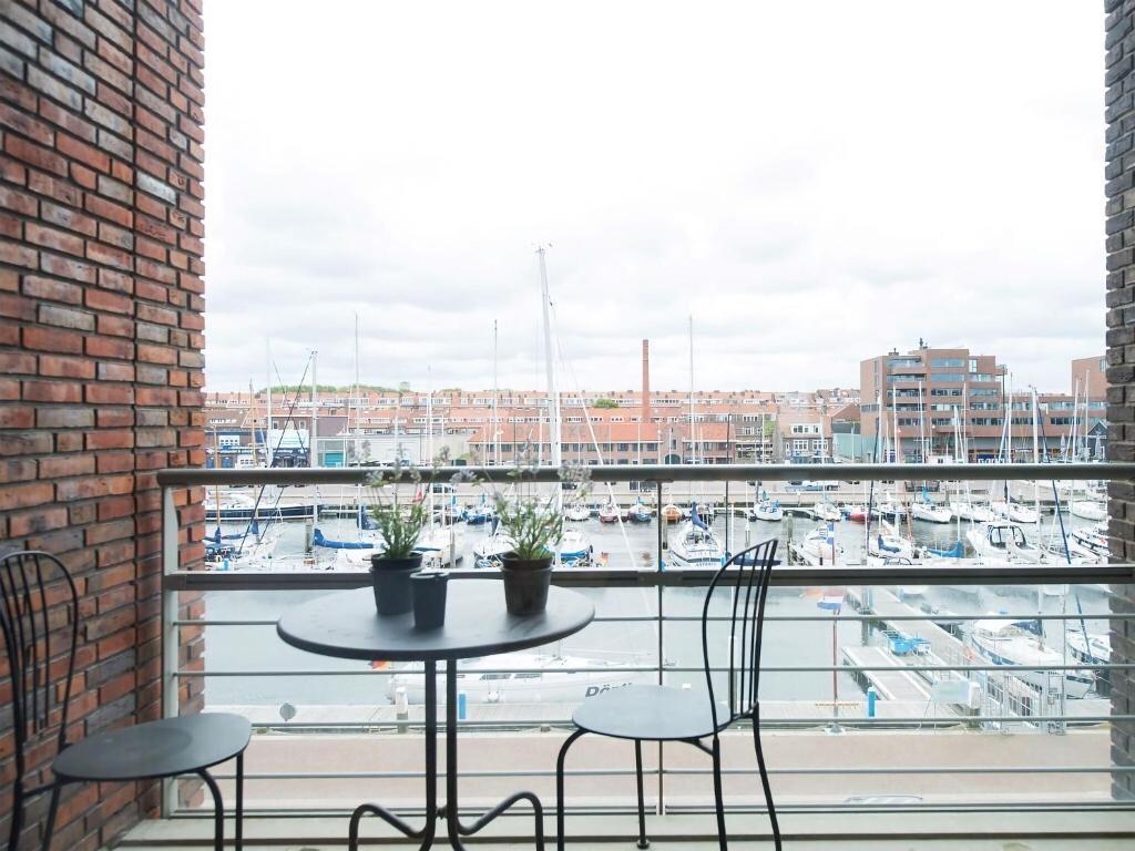 un tavolo e sedie su un balcone con vista sul porto di Sea view Apartment in Den Haag with Balcony a Scheveningen